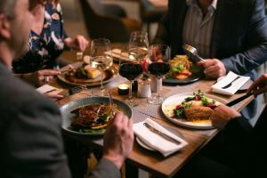 a group of people sitting around a table with plates of food at Seven Villa Hotel & Spa in Johannesburg