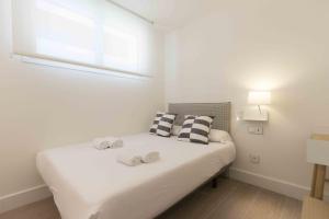 a bedroom with a bed with two towels on it at The Rentals - Preference Brunet in San Sebastián