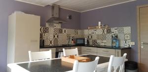 a kitchen with a table and chairs in a kitchen at Les terrasses in Malmedy