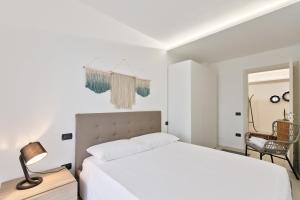 a white bedroom with a bed and a chair at CASA AGATA in Vicenza