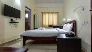 a hotel room with a bed and a telephone at Woodside residency in Thekkady