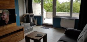een woonkamer met een bank en een tv bij Les terrasses in Malmedy