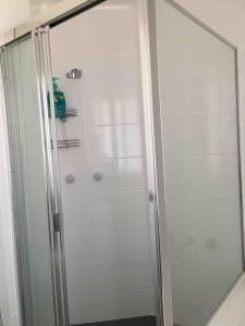 y baño con ducha y puerta de cristal. en Cozy 3BR Townhouse in Liverpool CBD with parking, en Liverpool