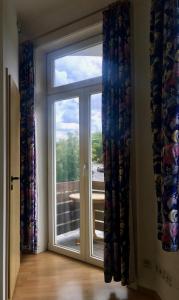 a room with a sliding glass door with a window at Pension Akropolis in Rellingen