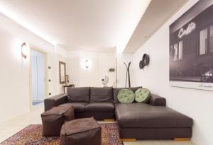 a living room with a brown couch and a rug at CASA AGATA in Vicenza