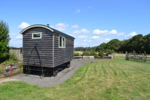 a small house sitting in the middle of a field at Rose Shepherds Hut in Badlesmere