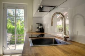 a kitchen with a sink and a large window at Ferienhäuser Südwind in Hiddensee
