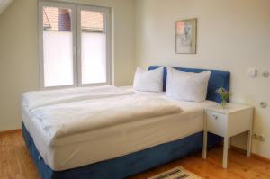 a bedroom with a large bed with a window at Ferienhäuser Südwind in Hiddensee