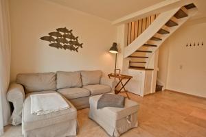 a living room with a couch and a staircase at Ferienhäuser Südwind in Hiddensee