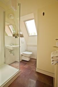 baño con aseo y lavabo y ventana en Ferienhäuser Südwind en Hiddensee