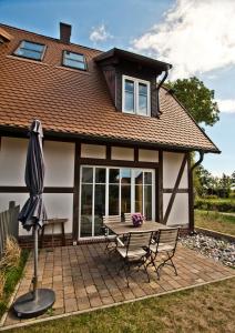 a house with a picnic table and an umbrella at Ferienhäuser Südwind in Hiddensee
