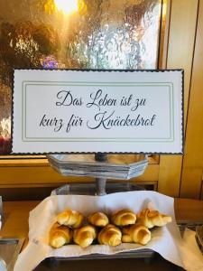 a plate of buns on a table with a sign at Tennis- und Freizeitzentrum Neudörfl in Neudörfl
