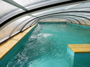 a swimming pool with blue water in a building at Penzion Harmonika in Nová Vráž