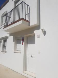 Edificio blanco con puerta y balcón en Luna de Atlanterra, en Zahara de los Atunes