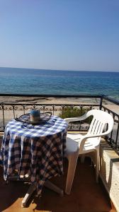 a table and chairs on a balcony overlooking the ocean at Eva's seafront house in Mytilini
