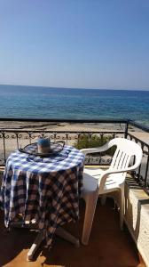 a table and chairs on a balcony overlooking the ocean at Eva's seafront house in Mytilini