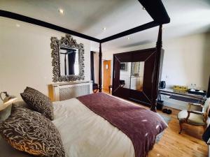 a bedroom with a large bed and a large window at The Old Lodge in Stroud