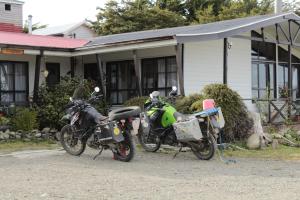 dwa motocykle zaparkowane przed domem w obiekcie Hospedaje Isla Magdalena w mieście Punta Arenas