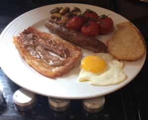 - une assiette de petit-déjeuner avec des saucisses, du bacon et des haricots dans l'établissement L'Ancienne Boulangerie, à Collinée