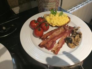 une assiette de nourriture avec des œufs au bacon, des champignons et des tomates dans l'établissement L'Ancienne Boulangerie, à Collinée