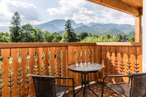 uma mesa e cadeiras numa varanda com montanhas em Royal Hill Residence em Zakopane