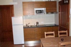 a kitchen with a white refrigerator and a microwave at Apartamentos Turisticos Rurales El Pua in Cazalla de la Sierra