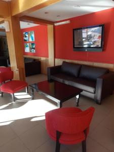 a living room with a couch and a table and chairs at Marcopolo Suites Calafate in El Calafate