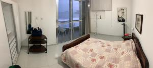 1 dormitorio con 1 cama con edredón rosa y blanco en Apto Pitagueiras - Vista incrível, en Guarujá