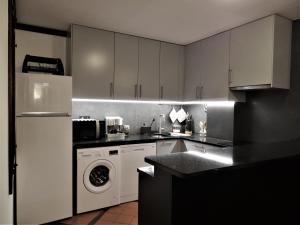a kitchen with a white refrigerator and a washing machine at Our Sunset Spot in Zambujeira do Mar