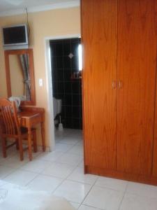 um quarto com uma cozinha com uma mesa e uma porta de madeira em Koiketla Guesthouse em Pretoria