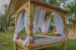 a wooden bed with a canopy in a yard at Maramures Landscape in Moisei