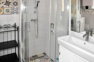 a white bathroom with a shower and a sink at Diamond Astoria Apartments in Budapest