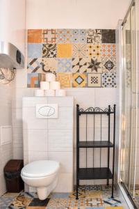 a bathroom with a toilet and tiles on the wall at Diamond Astoria Apartments in Budapest