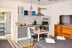 una pequeña cocina con mesa, mesa y sillas en Diamond Astoria Apartments, en Budapest