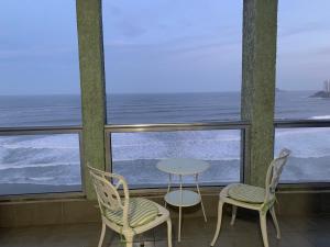 una mesa y dos sillas frente a una ventana en Apto Pitagueiras - Vista incrível, en Guarujá