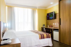ein Hotelzimmer mit einem Bett und einem Fenster in der Unterkunft Hotel Vinocap in Bento Gonçalves