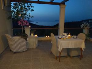 a table and chairs on a balcony at night at New Country House Salvia in Sitia