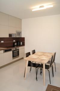 cocina con mesa de madera y sillas en Holiday Apartman with Free Parking, en Győr