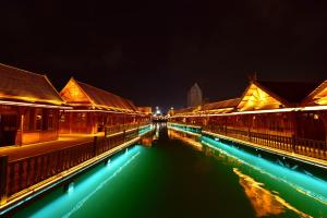 - une vue sur une rivière la nuit avec des bâtiments dans l'établissement Xishuangbanna Elephant Home Guesthouse, à Jinghong