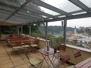 a balcony with tables and chairs and a view of a city at Waldgasthaus in Hochburg