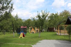 a park with a playground with play equipment and trees at Maramures Landscape in Moisei