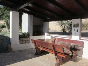 a wooden bench sitting under a pavilion with a table at grabrova cove in Novi Vinodolski