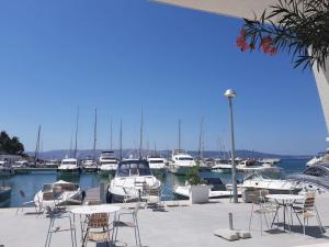 a marina with tables and chairs and boats in the water at grabrova cove in Novi Vinodolski