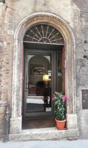 una entrada a un edificio con una puerta con una planta en B&B Alle Due Porte, en Siena