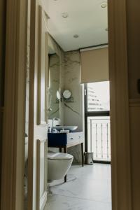 فندق ماجستيك في بودفا: حمام به مرحاض أبيض ومغسلة