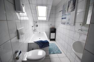 a white bathroom with a sink and a toilet at Ferienwohnung Troisdorf in Troisdorf