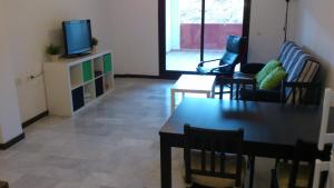 a living room with a tv and a table and chairs at Apartamento Ayamonte golf Costa Esuri in Ayamonte