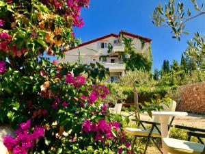 einen Garten mit Blumen und ein Gebäude im Hintergrund in der Unterkunft Villa Dinastija in Kali + 48 Fotos