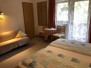 um quarto de hotel com duas camas e uma mesa e uma janela em Gästehaus Lackner em Oberau