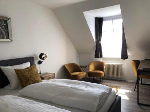 1 dormitorio con cama, sillas y ventana en Hotel Restaurant Haus Vorst, en Tönisvorst